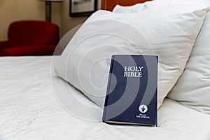 Gideons Bible on bed in hotel room