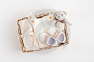 Gift basket with gender neutral baby garment and accessories. Care box of organic newborn cotton clothes photo