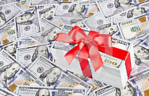 Gift with big red bow ribbon made of united states dollars curr