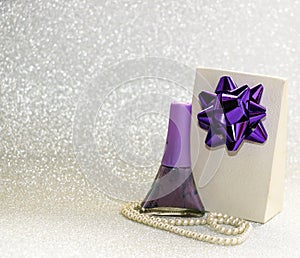 Gift with bow, jewelry and cosmetics for women on brilliant background