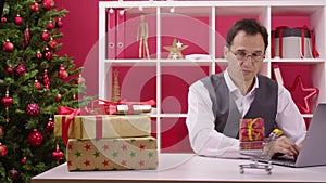 Gift box arrives at supermarket cart on table desk in Christmas decorated office