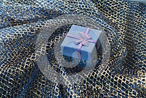 Gift box on a background drapery