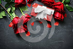 Gift box and beautiful roses on dark background