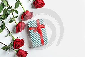 Gift box and beautiful roses on white background