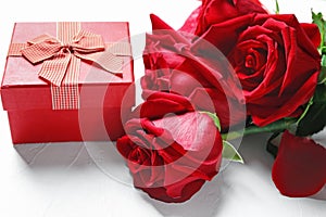 Gift box and beautiful roses on white background