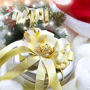 Gift Box with Big Golden Ribbon on Christmas Decoration Background