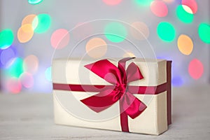 Gift box on a blurry background of holiday lights. Christmas lights, beautiful bokeh. Greeting card. The concept of the