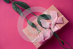 Gift box and bouquet of flowers on pink background bow holidays top view