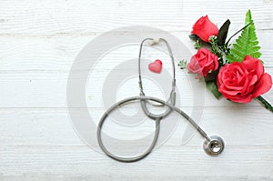 gift box, bouquet of red roses, stethoscope Red hearts, isolate on a wooden table white backdrop, Valentines Day concept.
