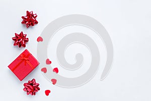 Gift box, bows and red hearts on a white background.