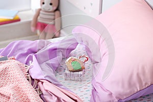 Gift box with candy cane and gingerbread on bed in children`s room. St. Nicholas Day