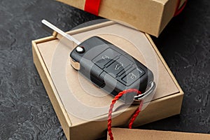 Gift box with car keys with remote control alarm system with red ribbon bow and label.