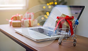 Gift box in cart and laptop on table at home in christmas time for shopping online concept