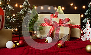 Gift box, christmas ball and christmas tree on red yarn wool with bokeh light background