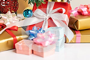 Gift box and christmas ball with small bell under the pine