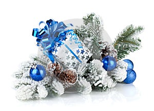 Gift box and christmas decor on snowy fir tree