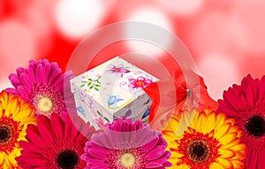 Gift box and colorful flowers with blur bokeh background
