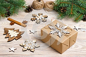 Gift box in craft paper with Christmas decoration, twine rope, concept background, top view on wood table surface. Christmas ornam