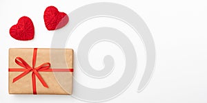 Gift box of craft paper with red bow and ribbon top view for Valentines day isolated on white background. Flat lay. Copy space