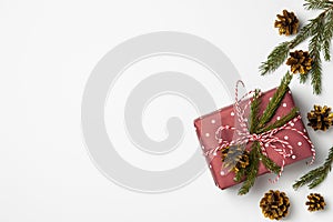 Gift box decorated with fir branches on a white background