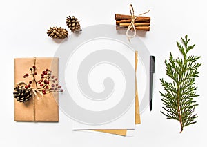 Gift box in eco paper and a letter on white background. Christmas or other holiday concept, top view, flat lay