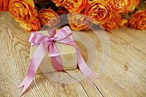 Gift box and flower bouquet on wooden background