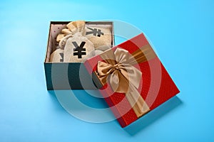 gift box full with RMB money bags on blue background