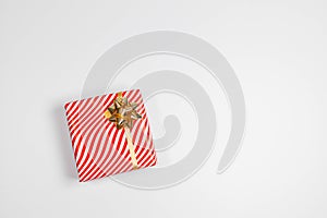 Gift box with gold ribbon on white background. Christmas and New Year holiday background. Top view, flat lay, copy space