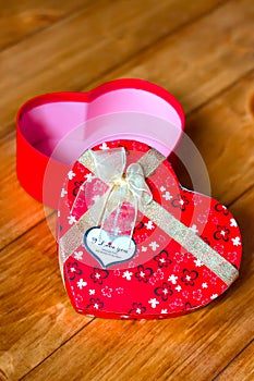 Gift box with heart shape with inscription i love you on wooden background