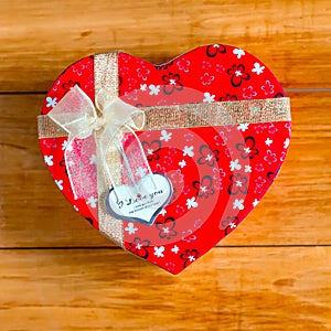 Gift box with heart shape with inscription i love you on wooden background