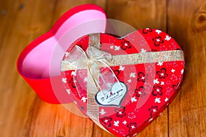 Gift box with heart shape with inscription i love you on wooden background