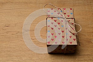 Gift box with hearts for Valentine`s day on an old oak table.