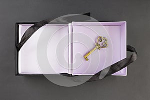 Gift box with a key at the bottom on a black