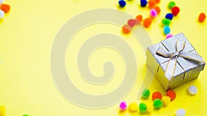 Gift box with multi-colored confetti on a yellow background.
