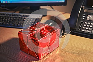 A gift box on the office desk at Christmas and New Year Eve. Surprises and gifts for the holidays