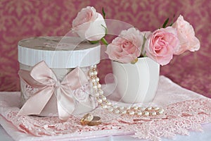 Gift box, pearls, wedding rings and roses