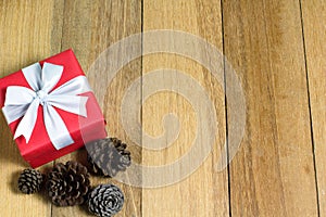 Gift box and pine cones on wood table with copy space
