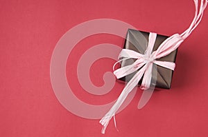 Gift box with pink bow on red background