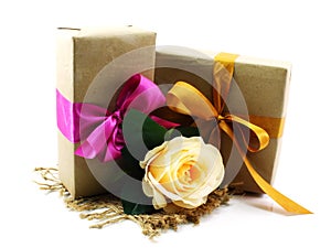 Gift box with pink ribbon bow and rose flower