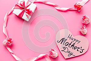 Gift box with pink ribbon over Happy Mothers day greeting card