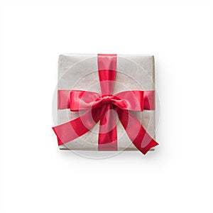 Gift box present isolated with clipping path with red bow satin ribbon over brown wrapping paper on white background