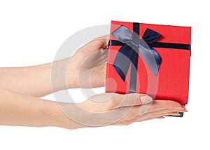 Gift box with a red lid and a blue bow in hand