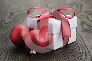 Gift box with red ribbon bow and christmas balls