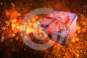 Gift box with red ribbon on golden bokeh background. 3d