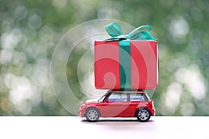 Gift box with red ribbon on miniature car for Christmas and New Year\'s Day or Greeting season