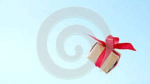 Gift box with red ribbon spinning on blue background. 360 degree rotation. zero gravity. levitation. copyspace. Concept sales, d