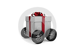 Gift box with red ribbon on wheels