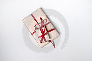 Gift box with a red ribbon on a white background. Top view, flat