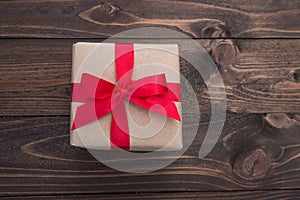 Gift box with red ribbon on wooden table for valentines day