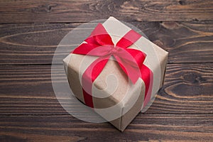 Gift box with red ribbon on wooden table for valentines day